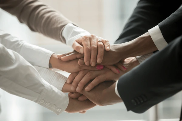 diverse-people-putting-stacked-hands-600nw-1022451727